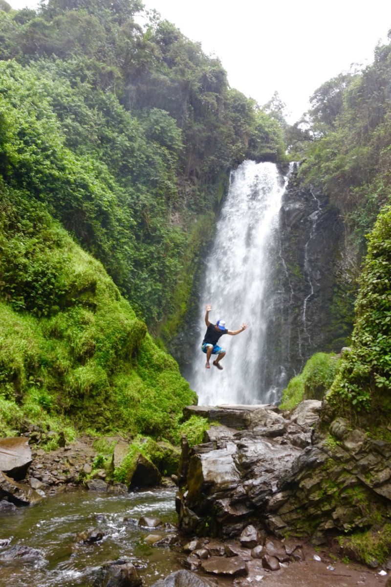 Jumping Jedd in front of waterfall, Otavalo and San Antonio de Ibarra, Ecuador | Intentional Travelers