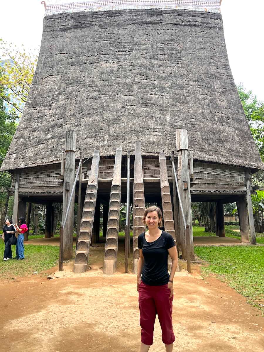 Michelle in front of stairway and hut at Ethnological museum