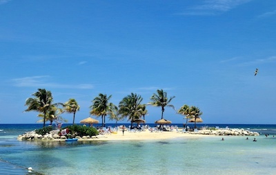 Jamaican island with tourists on beach