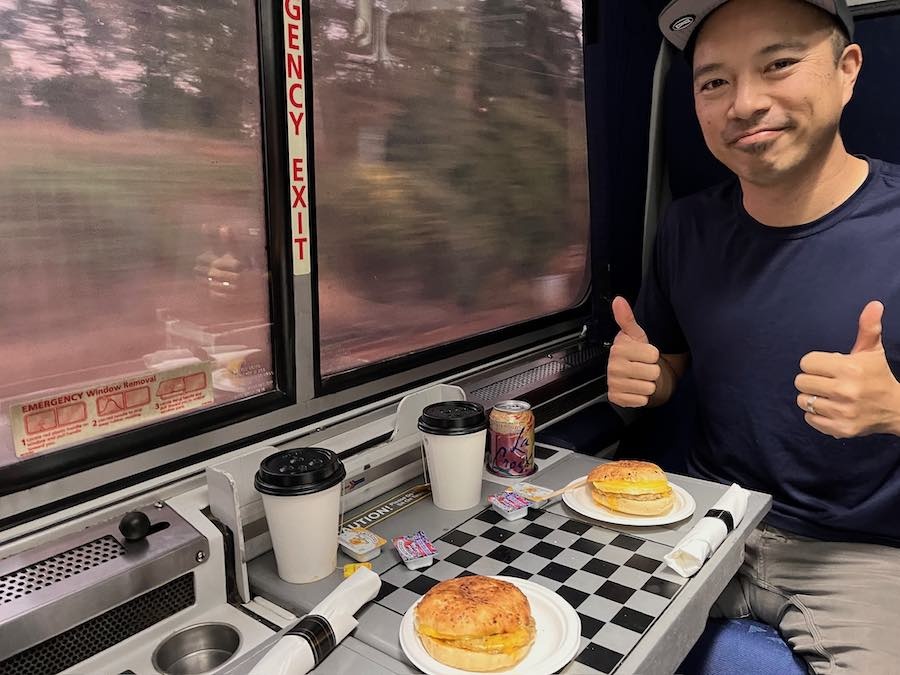 Jedd with breakfast sandwiches and hot tea breakfast in roomette