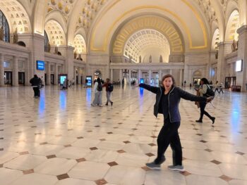 Michelle walking through DC station with big archway in background