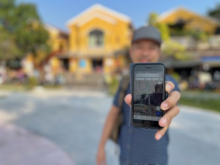 Jedd showing smartphone with Google Maps app displaying, Vietnam destination blurred in background