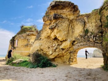 beach with yellow rock and arch cave