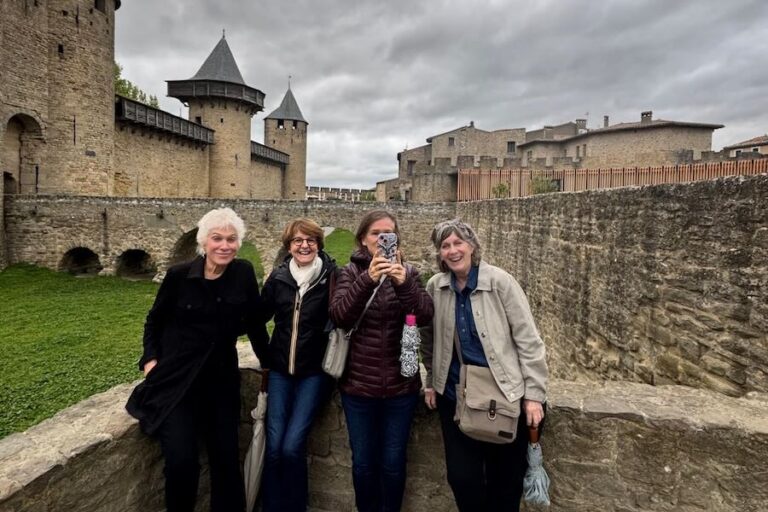 women travelers taking phone photo in front of castle